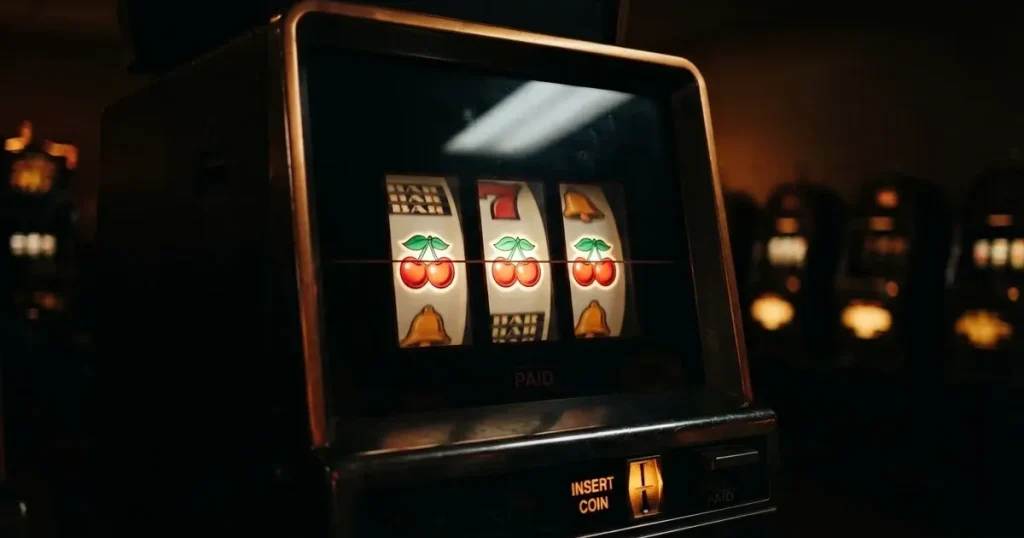 Rullarna på en spelautomat stannar i rad, klarröda körsbär lyser i den mörka spelhallen — casino erbjudanden i sverige